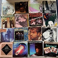 Top-down photo showing all 16 vinyl record covers in a grid, visible artist names and artwork.