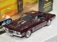 Dark maroon die cast model car of 1968 Dodge Charger R/T with opening doors and detailed interior.