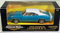 Front and side view of boxed 1969 Dodge Charger R/T die cast model by Ertl Collectibles in blue, white roof and stripe.