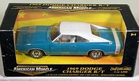 Front and right side view of 1969 Dodge Charger R/T 1:18 scale die cast model in original box with visible yellow interior base and black box edges with yellow and black labeling.