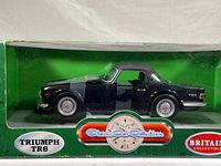 Front side view of the Britains 1:18 scale Triumph TR6 die cast model car in original sealed green box with Classic Car Collection branding.