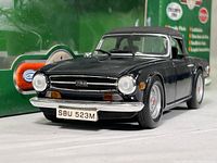 Front view of black Triumph TR6 1:18 scale die cast model car showing front grille, license plate SBU 523M, headlights, and black soft convertible top.
