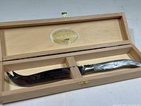 Claude Dozorme carving knife displayed in wooden storage box with the Claude Dozorme logo inside the lid.