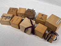 Image showing 10 Japanese wooden boxes from the lot arranged in two rows, some with ribbons, all with natural wood tones and some with calligraphy on lids.