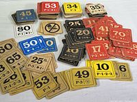 Photo showing multiple stacks of colored wooden tags with numbers, codes, and arrows.