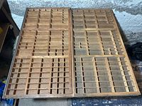 Two large antique wooden printing trays side by side showing compartments and condition