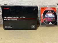 Box for Sigma 18-200mm F3.5-6.3 DC OS lens and Optex 72mm UV filter in packaging.