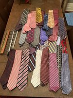 Full view of all 26 ties showing assorted colors and patterns laid out flat on table