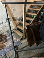 Metal clothing rack in gray color, showing the horizontal bar and adjustable vertical supports with base.