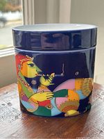 Covered porcelain box with colorful designs and closed lid.