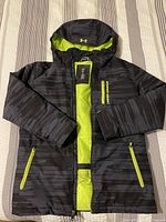 Front view of jacket open showing yellow interior lining and front zipper with two side zip pockets