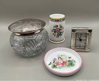 Photo shows all four items in the lot: cut glass dresser jar with silver plate lid, cylindrical Coalport vase, Royal Worcester trinket plate with fairy design, small rectangular sterling quartz clock.