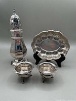 Photo showing entire lot including sugar caster, scalloped serving plate, and two sterling salts.
