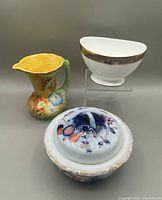 Three items displayed together: covered soap dish, footed bowl, and pitcher