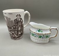 Photo showing both the Copeland Spode mug with vintage illustration and the Royal Crown Derby Medway creamer with floral and gold detail side by side.