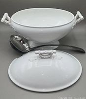 White porcelain tureen with handles and matching lid in front, and Brazilian pewter ladle placed behind the tureen.