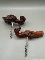Two vintage grapevine corkscrews with wooden handles carved to resemble grapevine wood, showing the corkscrews set side by side.