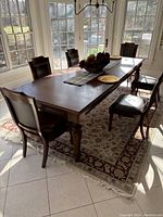 Rectangular wooden dining table with six matching chairs in room setting
