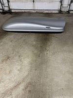 Side profile of silver Thule Evolution cargo box showing its streamlined, aerodynamic design and the Thule logo.