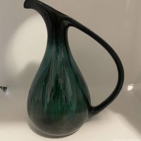 Large jug vase, showing its unique shape and gradient glaze from green to black with handle and spout.