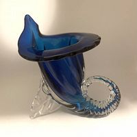 Side angle of blue and clear Murano glass cornucopia-shaped vase, showing twisted horn and curled base detail.
