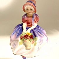 Front view of Royal Doulton Monica figurine holding flower basket, showing detailed facial features and painted dress.