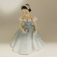 Front view of Royal Doulton The Bridesmaid figurine showing the blue and white dress, bouquet, and headpiece details.