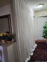 Full view of the white curtain hanging from ceiling, showing length, width and placement in hallway space.
