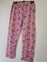 Full front view of pink and white checkered pajama pants with teddy bear and heart prints, showing elastic waistband and straight leg cut.