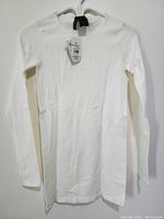 Full view of the ivory long sleeve sweater on hanger, showing its length, neck style, and overall shape.
