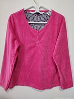 Front view of pink long sleeve sweater top with button detail on front neckline, size XL.