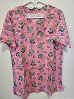 Pajama top front view hanging on a hanger, showing pink gingham with teddy bear and heart print pattern.