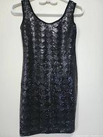 Full front view of black sleeveless sequin women's top on a hanger against a white background.