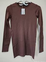 Front view of new women's brown long sleeve top size M/L with tags attached.