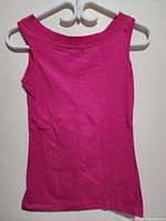 Front view of sleeveless magenta red women's top on a hanger.