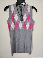 Front view of women's sleeveless sweater vest on hanger showing grey base with pink and white argyle pattern