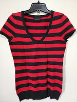 Front view of the women's LAVOCA striped V-neck short sleeve top hanging on a hanger, showing horizontal red and black stripes and ribbed edges.