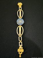 Full view of women's wristwatch showing linked bracelet in gold and silver tone.