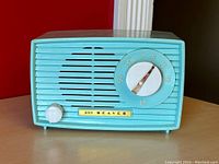 Front view of a small turquoise blue 1950s AM tube radio model 501 Beaver with tuning and volume knobs and speaker grille.