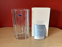 Crystal vase standing next to its white box with "Marquis by Waterford" text and a light blue booklet.