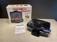 Hamilton Beach Meal Maker Express indoor grill in black, original box shown, grill wrapped in plastic, includes instruction manual.