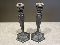 Pair of antique Victorian Gothic candlesticks with detailed etched designs on a hexagonal base.