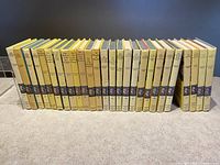 Full side view of all 26 Nancy Drew books from volumes 31 to 56 with yellow spines and consistent publishers marks.