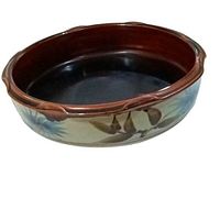 Side view of the round ironstone deep dish pie plate showing floral painted exterior and dark interior glaze.