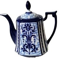 Front and side view of the vintage Bombay House blue and white porcelain tea or coffee pot showing decorative motifs and lid with pointed finial