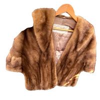 Front view of brown mink fur stole hung on a hanger showing the fur texture and collar.
