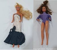 Two vintage Barbie dolls side by side. Blonde hair doll in black and white gown and brunette doll in purple leotard, displayed to show full body and outfit details.