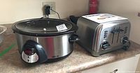 Photo showing both the Crock Pot slow cooker and Cuisinart toaster on a kitchen counter