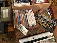 Boxed DVD sets arranged on a table showing Six Feet Under seasons 1-5, some Barney Miller, Cadfael, Vicar of Dibley and a large Bond 50 box set.