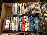 Photo showing a variety of DVDs and VHS tapes including Taxi, Harry Potter series, Avatar, and Riverdance VHS.